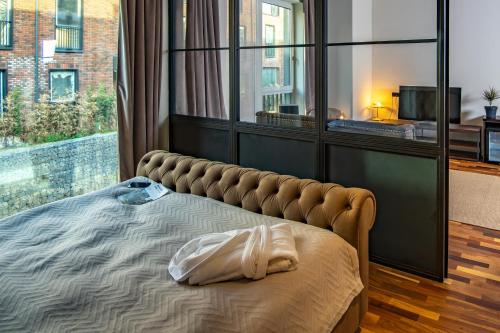 a large bed in a room with a large window at Warm House Apart Hotel in Almaty