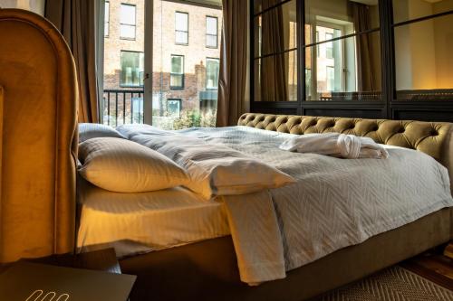 a bed in a room with a large window at Warm House Apart Hotel in Almaty