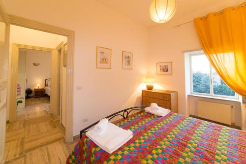 a bedroom with a bed with a colorful blanket at Frascati Country House in Grottaferrata