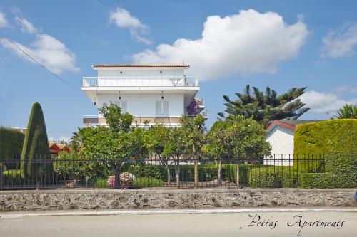 a white building with a fence in front of it at Pettas Apartments in Zakynthos Town