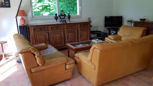 a living room with two chairs and a tv at L Eskemm in Plouaret