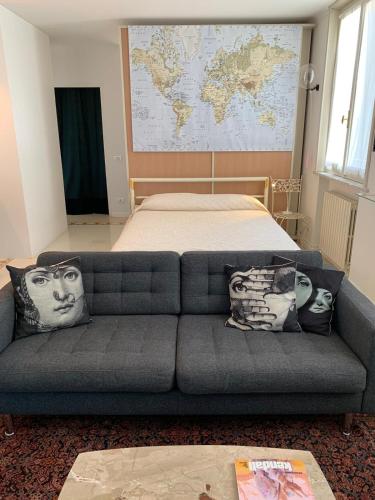 a couch in a room with a bed and a map at Masnadieri 18 in Parma