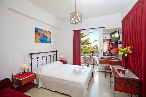 a bedroom with a white bed and a red curtain at Pettas Apartments in Zakynthos Town