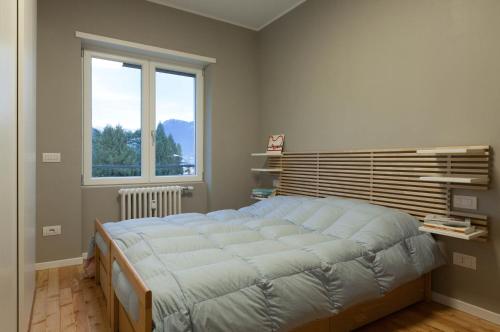 ein Schlafzimmer mit einem großen Bett und einem Fenster in der Unterkunft Appartamento Stelvio in Morbegno