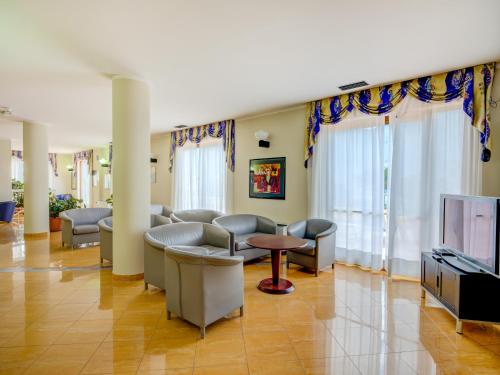 a waiting room with couches and a tv at Hotel Cristina in Limone sul Garda