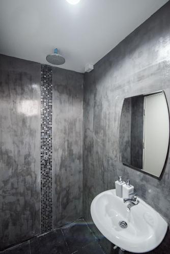 a bathroom with a sink and a mirror and a shower at Hua Hin Lae I Aoon in Hua Hin
