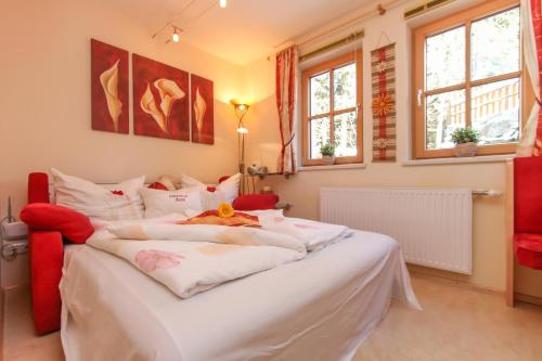 ein großes weißes Bett in einem Zimmer mit Fenstern in der Unterkunft Ferienwohnungen Anita in Fieberbrunn