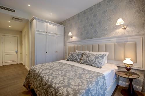 a bedroom with a bed and a table with two lamps at Hotel Passport Tbilisi in Tbilisi City