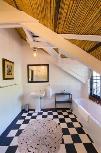 a bathroom with a sink and a bath tub and a sinkessment at Bartinney Private Cellar Banhoek in Stellenbosch