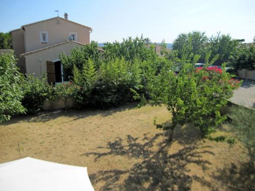 a garden with bushes and a house in the background at Holiday Home La Grèze by Interhome in Saint-Just