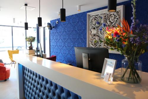 a lobby with a reception counter with a blue wall at Blue Mansion Hotel in Aalsmeer