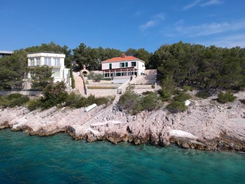 a house on a rocky island in the water at Villa Osibova in Milna