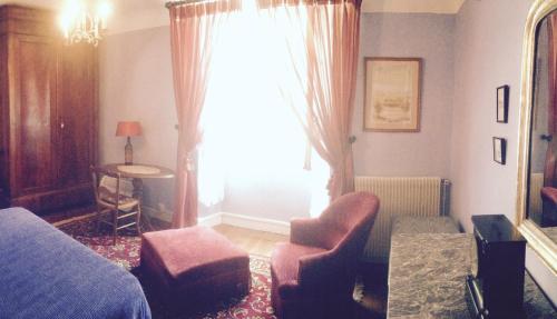 a living room with a bed and a window at Maison Lomprère in Fichous-Riumayou
