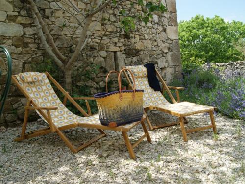 deux chaises et un panier assis à côté d'un mur dans l'établissement Holiday Home Du Brun by Interhome, à Bésignan