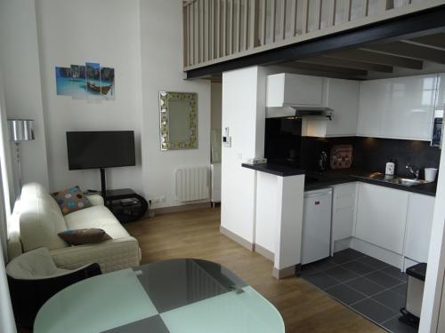 un salon avec une table et une cuisine dans l'établissement ORATORIENS HENRI IV, à Dieppe