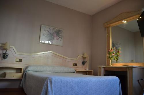 1 dormitorio con cama azul y espejo en Ana María, en Granada