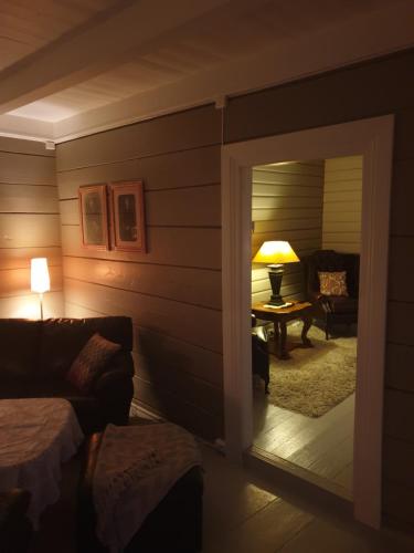 a room with a door leading to a living room with a couch at Fjords view in Sjøholt