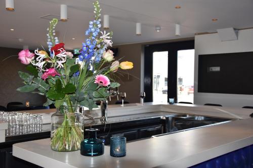 a vase of flowers on a counter in a kitchen at Blue Mansion Hotel in Aalsmeer