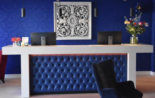 a blue room with a desk with a blue wall at Blue Mansion Hotel in Aalsmeer