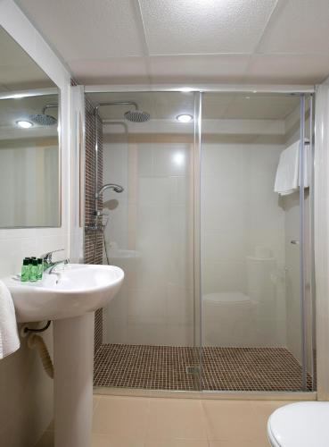 a bathroom with a glass shower and a sink at Hostal Roca in San Antonio