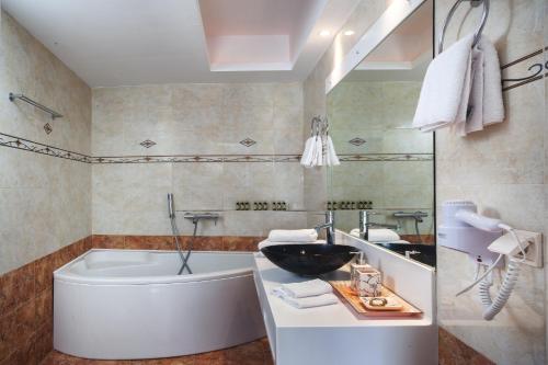 a bathroom with a tub and a sink at Arlene Suites in Mesaria