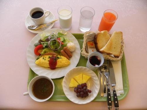 a tray with two plates of food and cups of coffee at Hotel Benex Yonezawa in Yonezawa