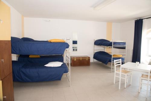 Habitación con literas azules y mesa. en Ostello Il Castagno, en Antrodoco