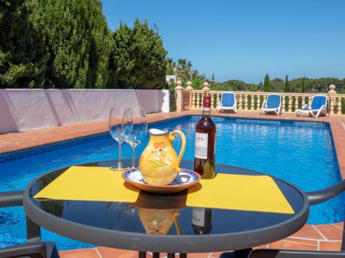 a table with a bottle of wine and wine glasses at Holiday Home Cala Vista by Interhome in Balcon del Mar