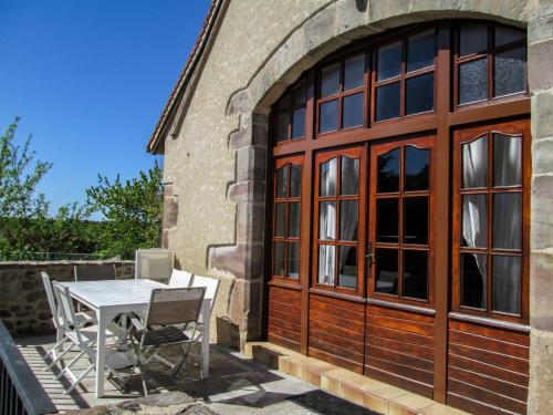 a patio with a table and chairs next to a building at Holiday Home La Grange by Interhome in La Valade