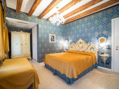 a bedroom with two beds and blue walls at Dimora Marciana in Venice