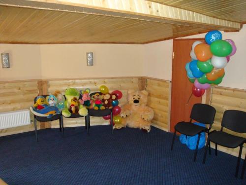a room with chairs and a teddy bear and balloons at Panorama Karpat in Yablunytsya