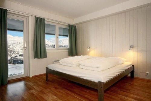 a bedroom with a bed with a view of a mountain at Skarsnuten Apartments in Hemsedal