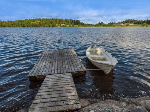 ein kleines Boot, das an ein Dock auf einem See gefesselt ist. in der Unterkunft Holiday Home Artturin mökki by Interhome in Kylmälä
