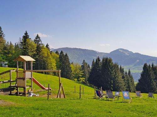 einen Spielplatz mit Stühlen und einer Rutsche auf einem Feld in der Unterkunft Apartment Mondi Resort-6 by Interhome in Malas