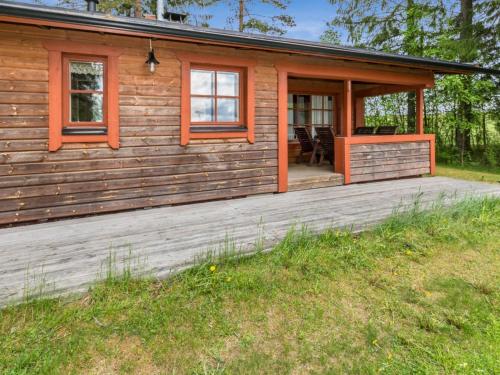 a log cabin with a porch and a deck at Holiday Home Kasilahti by Interhome in Kilvakkala