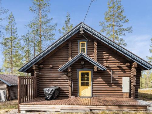 a log cabin with a porch and a yellow door at Holiday Home Riekonmarja by Interhome in Äkäslompolo