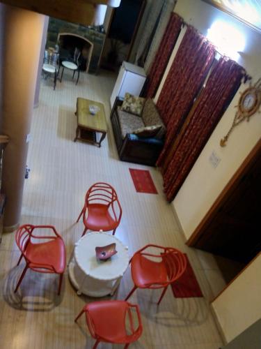 an overhead view of a living room with red chairs and a table at AMBIKA HOME STAY in Solan
