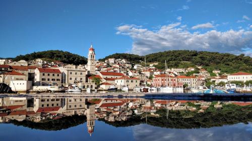 a town with its reflection in a body of water at Vila Maslinica in Pučišća