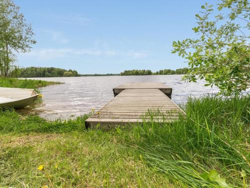 Un muelle de madera en un lago con un barco. en Holiday Home Juhala by Interhome, en Kilvakkala