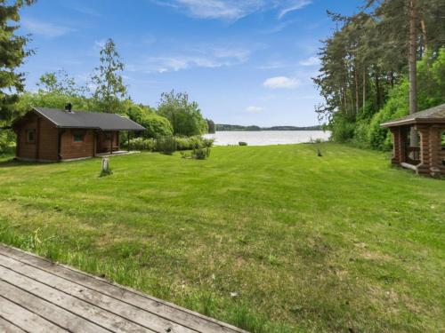 einen großen Hof mit einer Hütte und einem See in der Unterkunft Holiday Home Kasilahti by Interhome in Kilvakkala