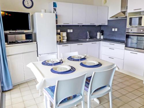 une cuisine blanche avec une table et des chaises blanches dans l'établissement Apartment Cap Sud-6 by Interhome, à Canet