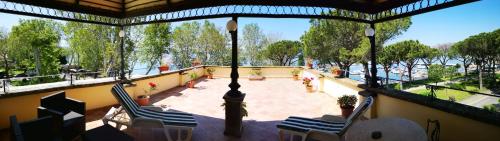 a balcony with chairs and a view of the water at Hotel Royal in Bolsena