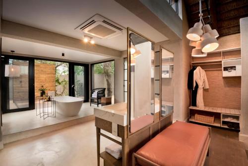 a bathroom with a tub and a large mirror at Lion Sands Ivory Lodge in Sabi Sand Game Reserve