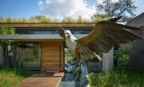 a statue of a bird sitting on top of a house at Lion Sands Ivory Lodge in Sabi Sand Game Reserve