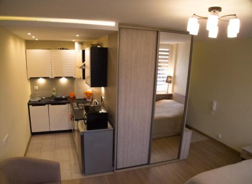 a room with a kitchen and a room with a bed at Studio Park Saski 1 & 2 in Sandomierz
