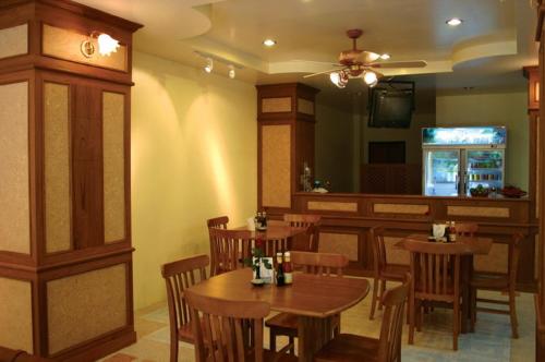 ein Restaurant mit Holztischen und einer Bar in der Unterkunft Amorn Mansion in Ao Nang Beach