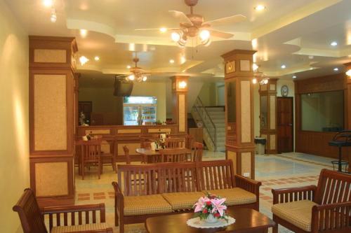 vestíbulo con sillas y mesas de madera y techo en Amorn Mansion, en Ao Nang Beach