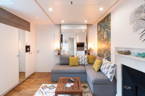 ein Wohnzimmer mit einem Sofa und einem Tisch in der Unterkunft Le Petit Botte in Rennes