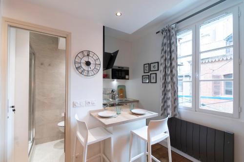 une cuisine avec une table et des chaises et une fenêtre dans l'établissement Le Petit Botté, à Rennes