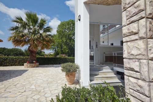 a courtyard with a palm tree and a building at Pettas Apartments in Zakynthos Town
